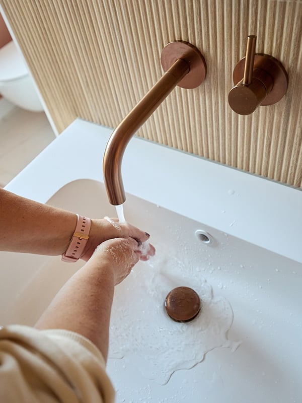 Handen worden gewassen onder de koperen inbouwkraan