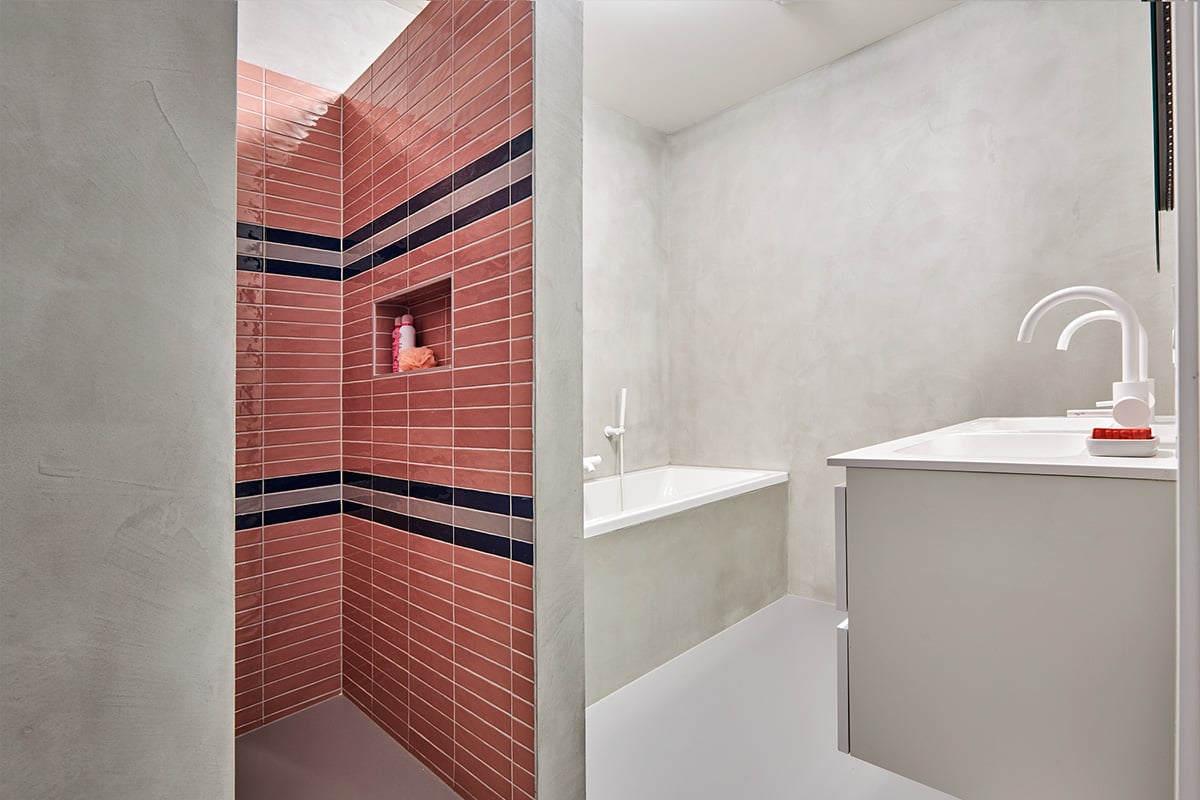 betonlook badkamer met roze tegels