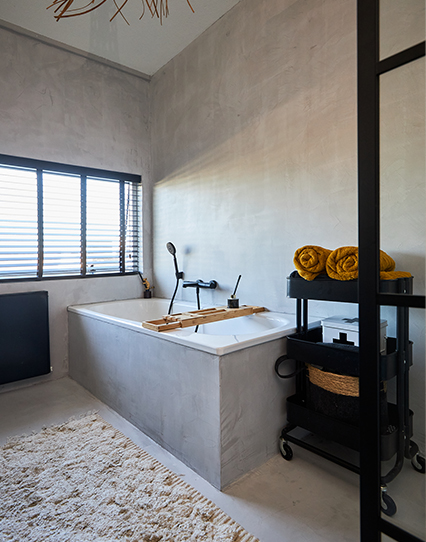 Moderne badkamer met betonlook bad